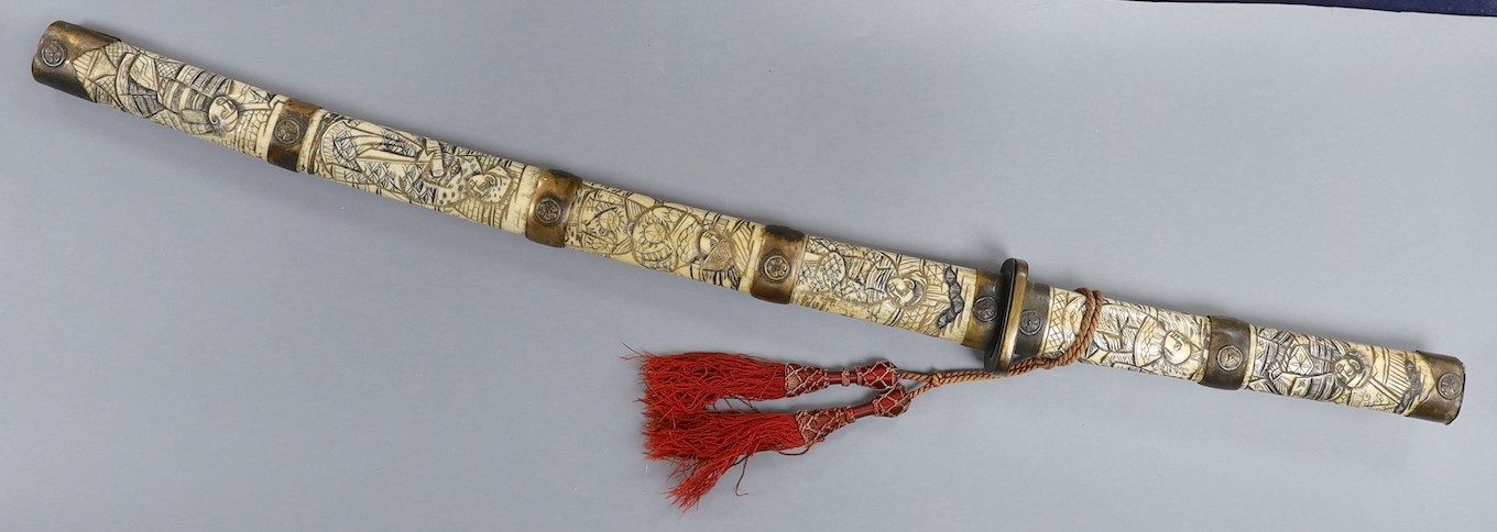 A late 19th century Japanese wakizashi sword, the blade 47.5cm, with sectional stag's horn scabbard and hilt carved with warriors and other figures, gilt metal mounted